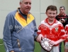North Antrim Youth Development Officer Paddy Gray presenting Loughgiel Shamrocks Team Captain Ruairi McCormick with the TeamKit U14 Division 2 Airborne Hurling League Shield